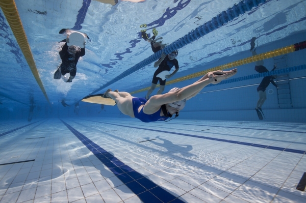 Beginners Guide to Freediving - safety for freediving - Freediver swimming in the Dynamic Pool Discipline with Safety on the surface