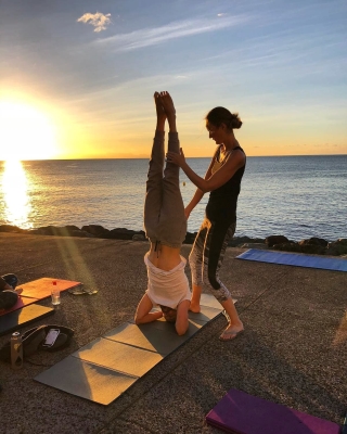 Yoga headstand at sunrise by the sea in Tenerife
